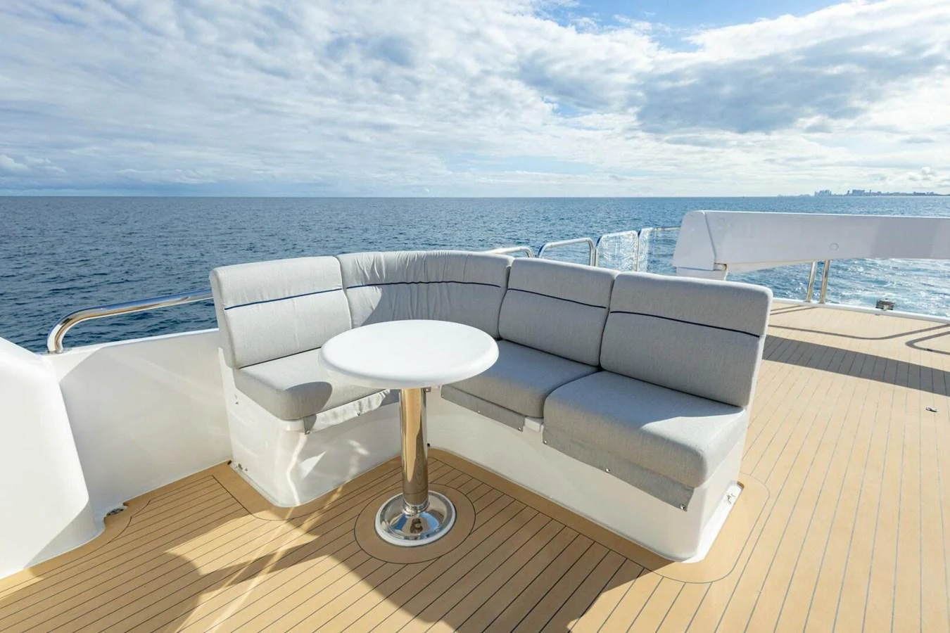 The sundeck features a comfortable seating area with a round table, perfect for enjoying the ocean views. aboard BOBBI TOO Yacht for Sale