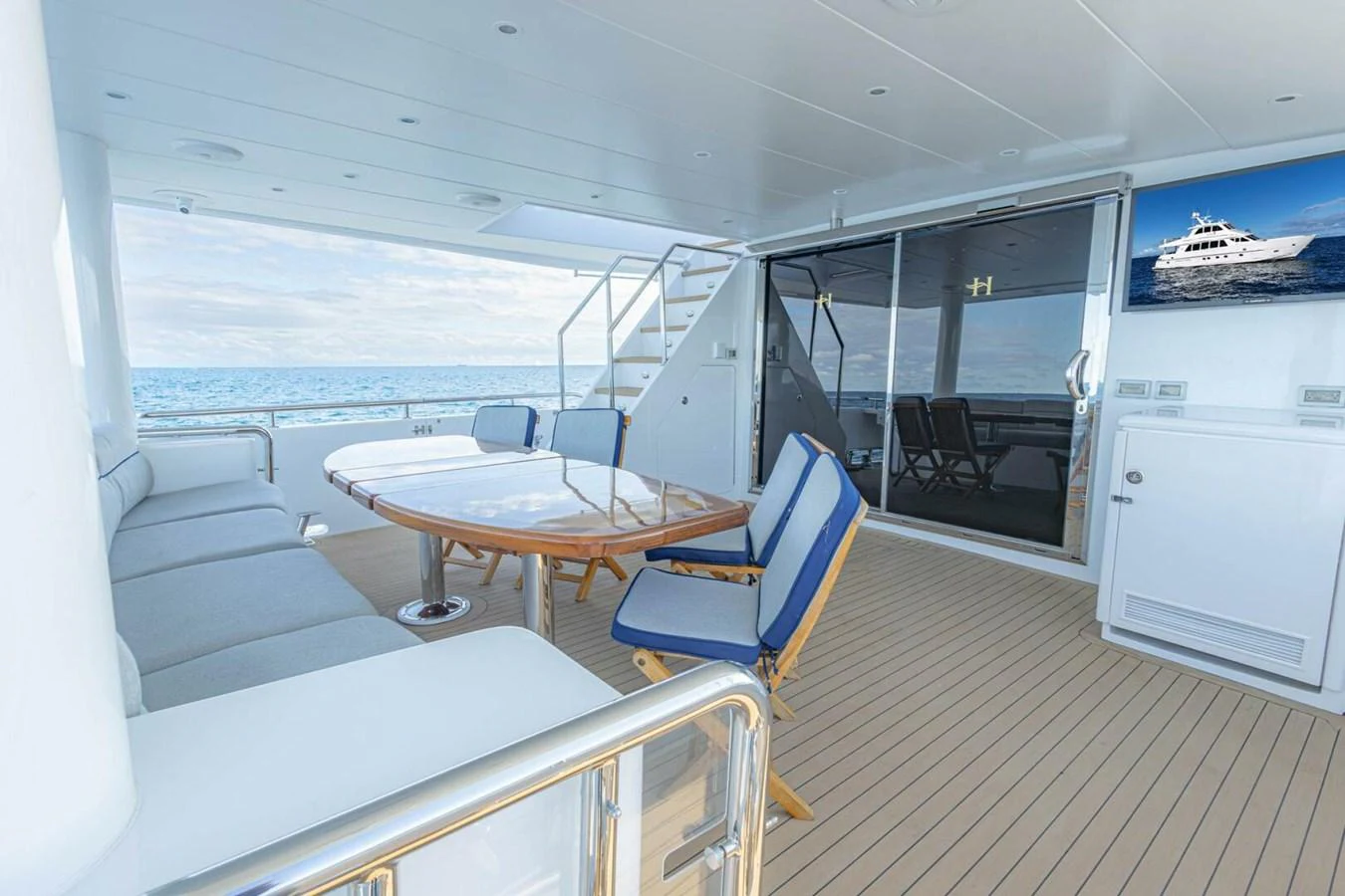 The aft deck features comfortable seating and a dining area with a view of the ocean. aboard BOBBI TOO Yacht for Sale
