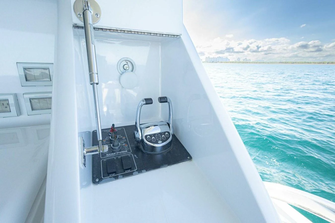 A close-up view of the yacht's control panel with a scenic ocean backdrop. aboard BOBBI TOO Yacht for Sale