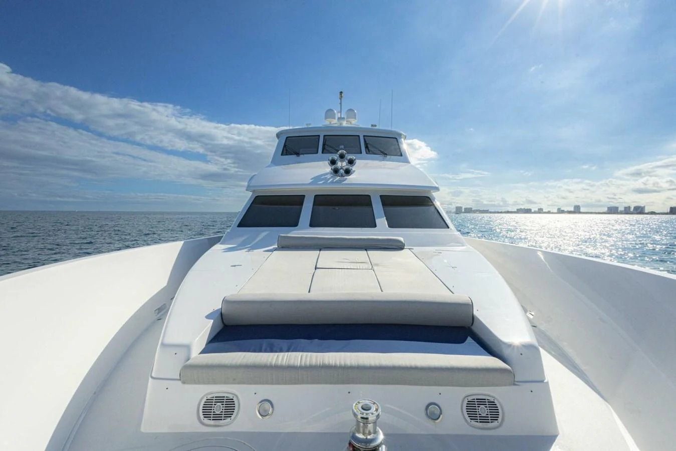 The yacht's foredeck offers a spacious sunbathing area with plush cushions, set against a stunning ocean backdrop. aboard BOBBI TOO Yacht for Sale