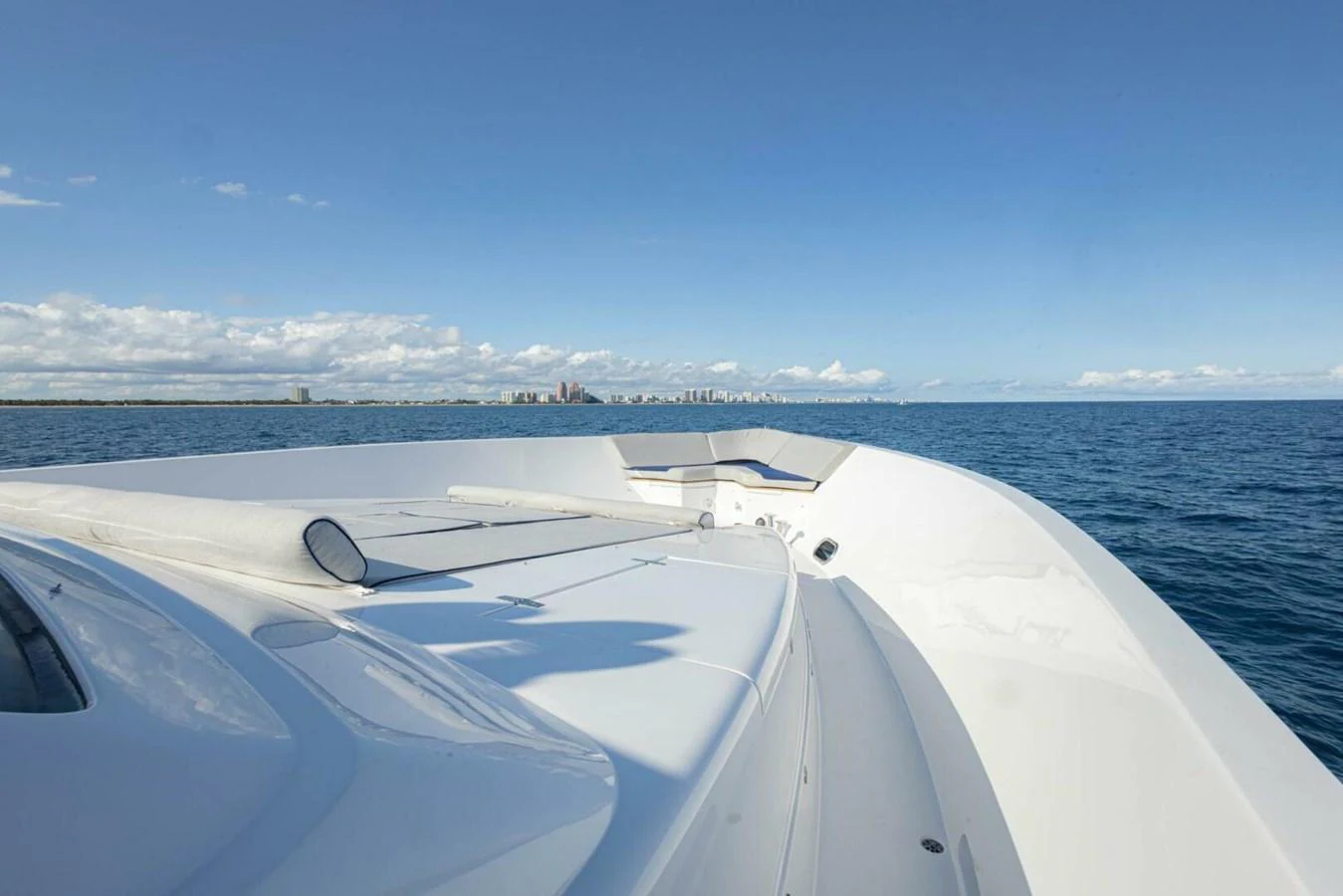The yacht's sleek bow cuts through the calm waters under a clear blue sky. aboard BOBBI TOO Yacht for Sale