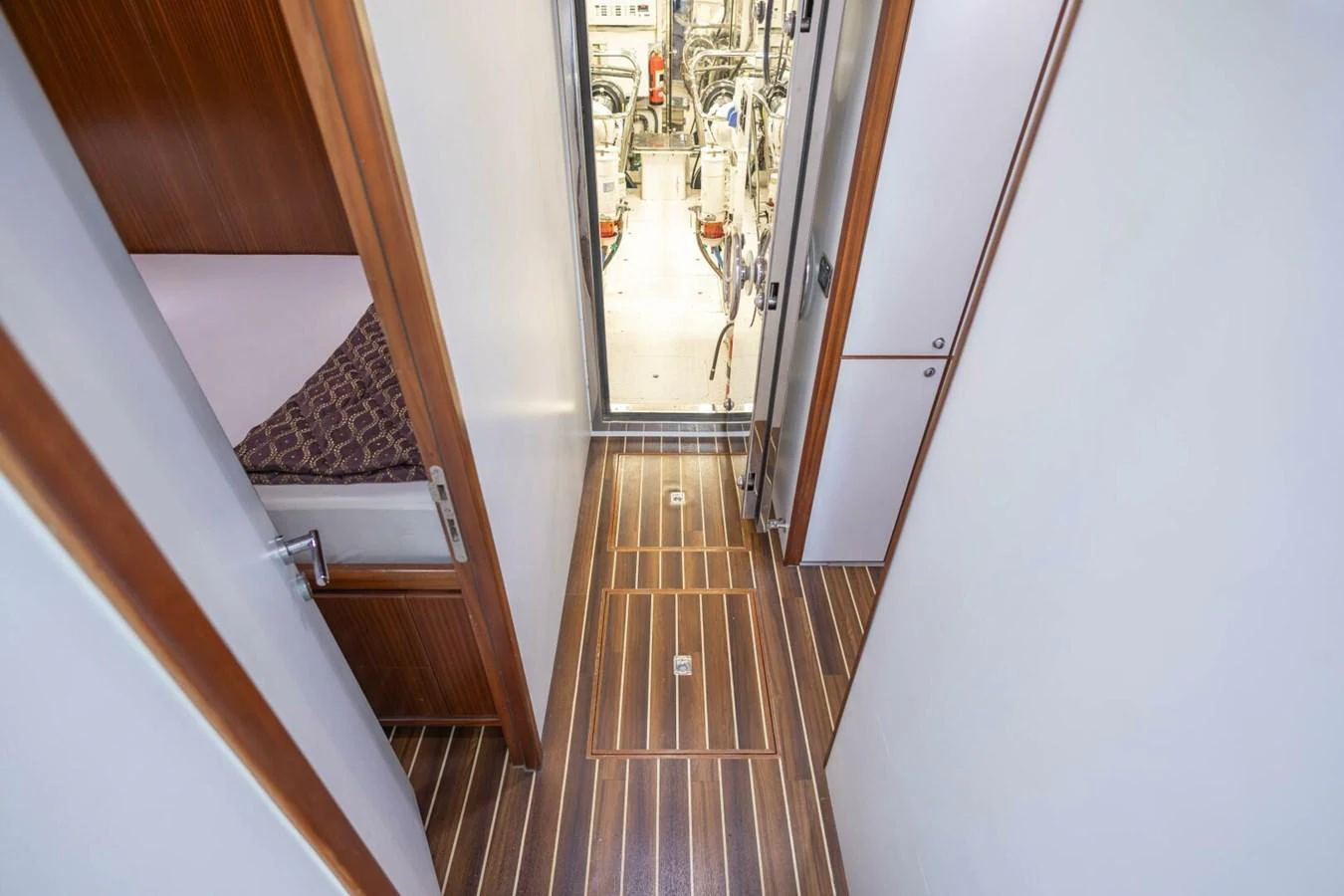 A corridor with wooden flooring leading to the engine room. aboard BOBBI TOO Yacht for Sale