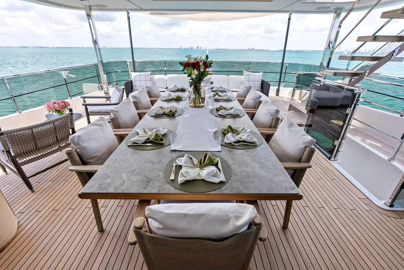 a table set for a meal on a deck overlooking the ocean aboard LUMPASAURUS Yacht for Sale