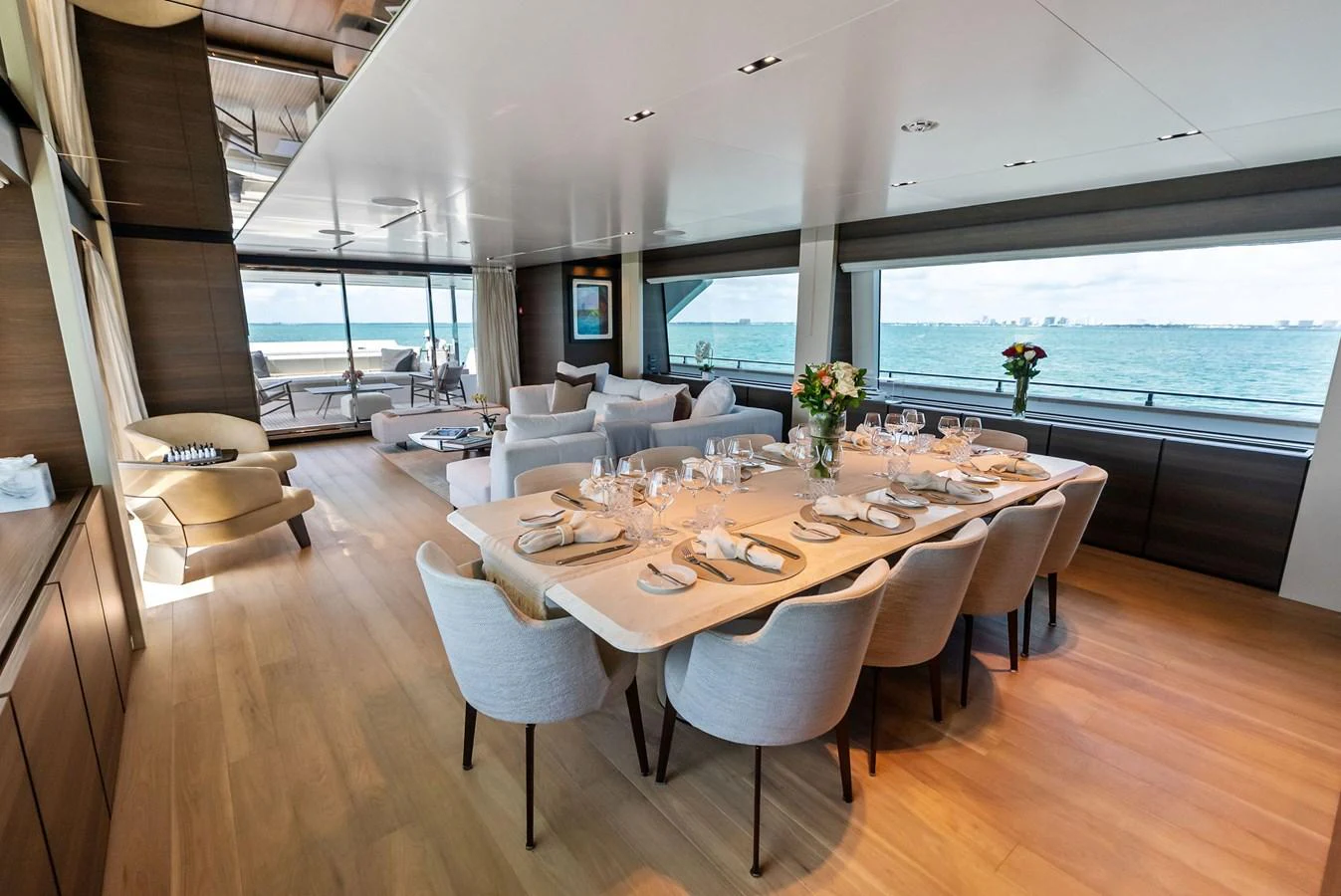 a large dining table with white chairs aboard LUMPASAURUS Yacht for Sale