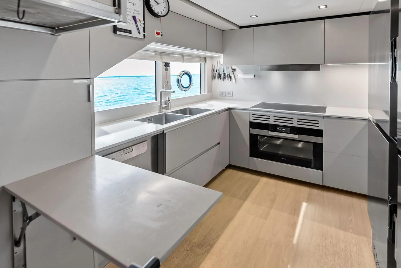 a kitchen with white cabinets aboard LUMPASAURUS Yacht for Sale