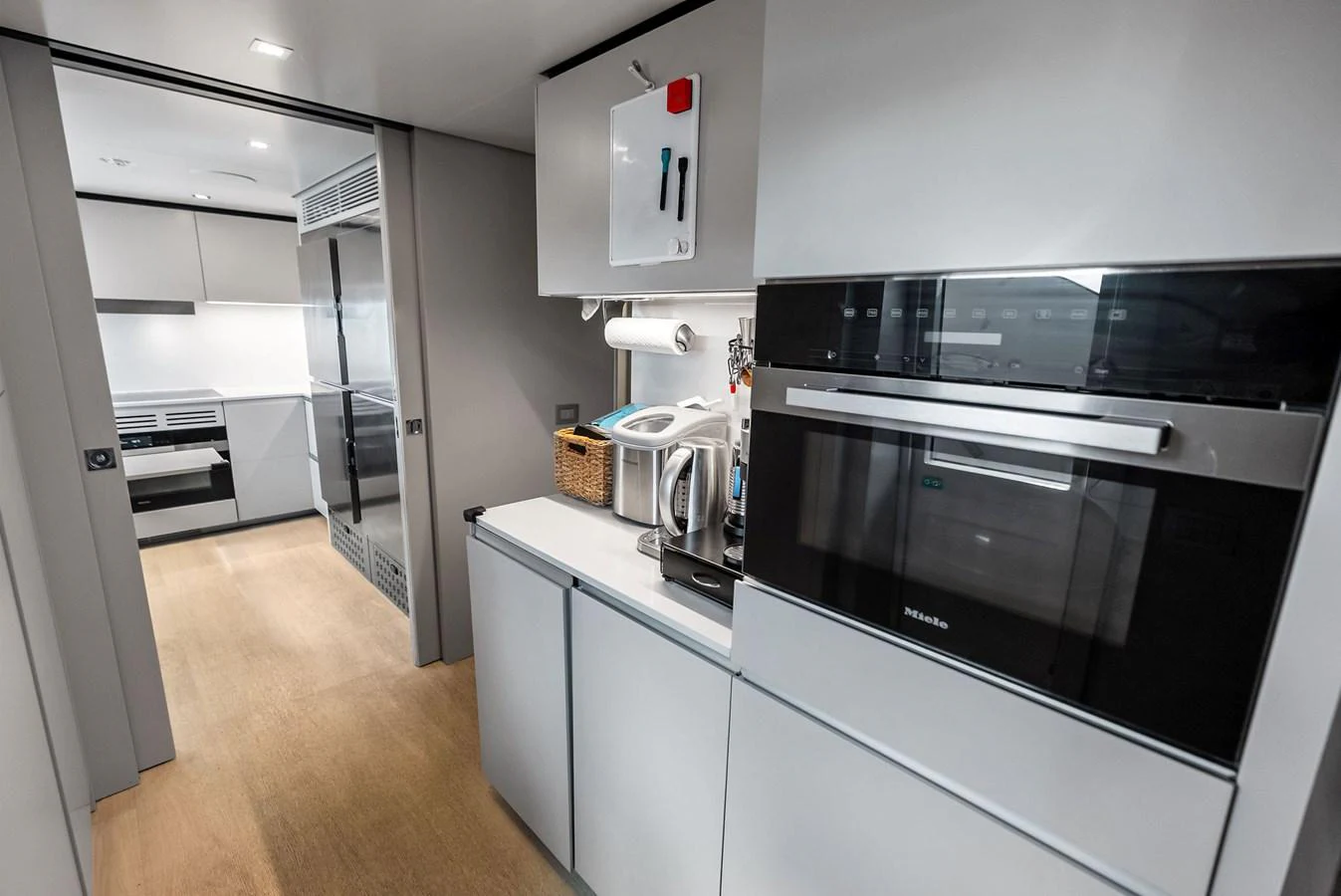 a kitchen with white cabinets aboard LUMPASAURUS Yacht for Sale