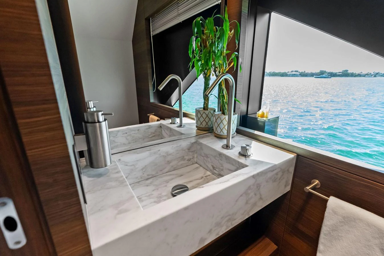 a bathroom with a sink and a plant in the window aboard LUMPASAURUS Yacht for Sale