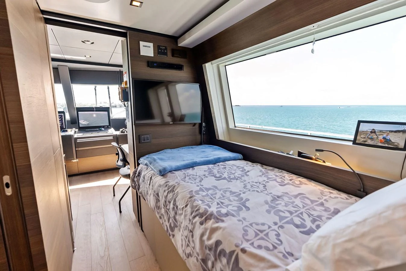 a bedroom with a bed and a window aboard LUMPASAURUS Yacht for Sale