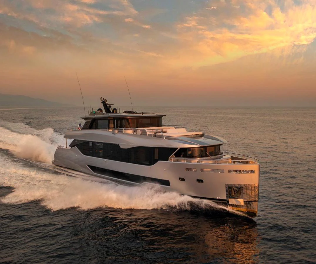 A sleek and modern yacht cruises through calm waters at sunset. aboard PESA II Yacht for Sale