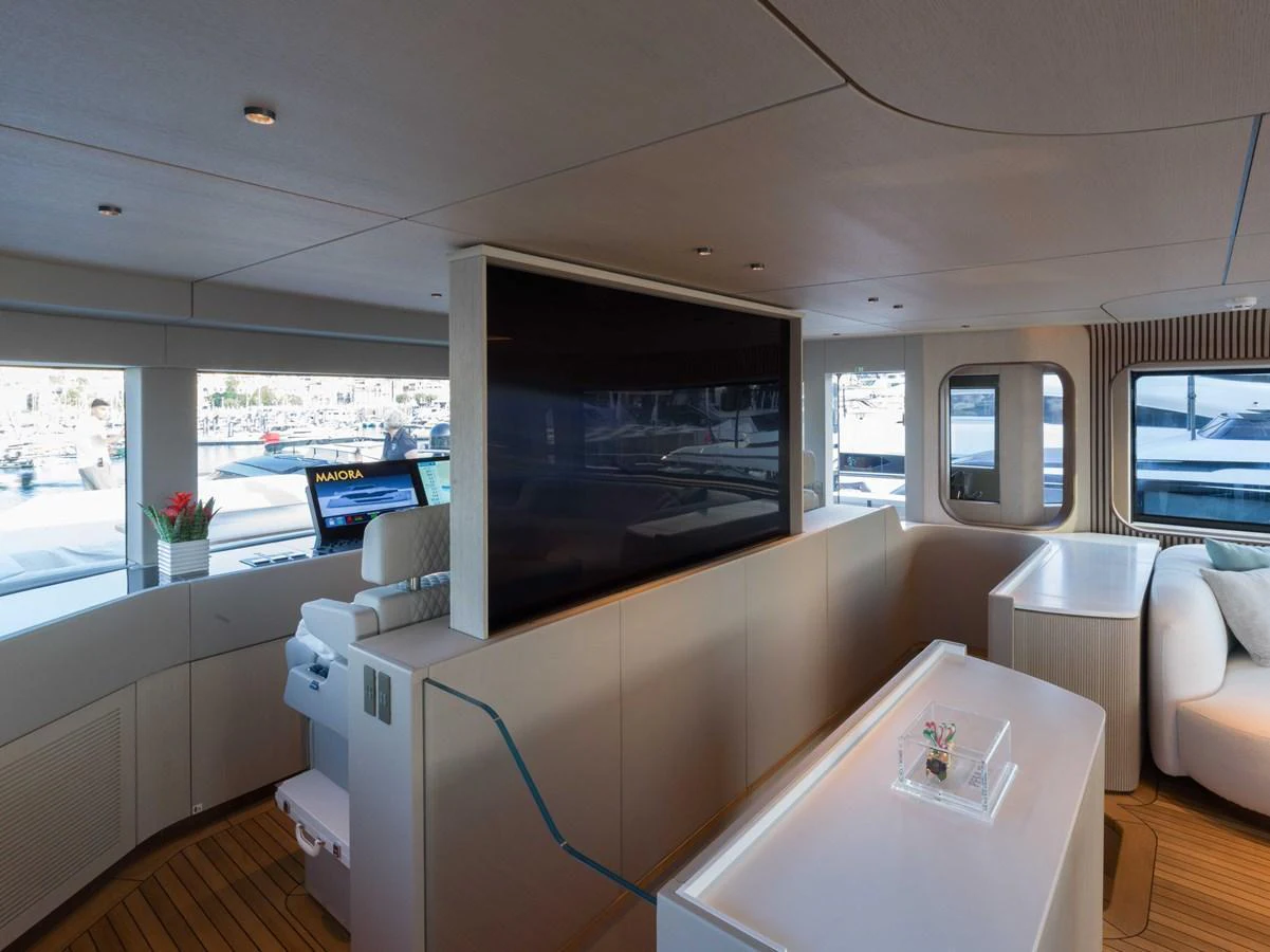 The salon features a modern design with large windows offering ample natural light and a comfortable seating area. aboard PESA II Yacht for Sale