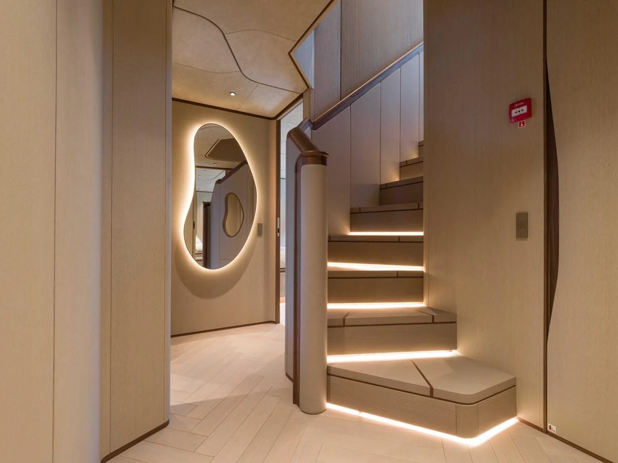 A modern yacht interior featuring a stylish staircase with ambient lighting and contemporary design elements. aboard PESA II Yacht for Sale