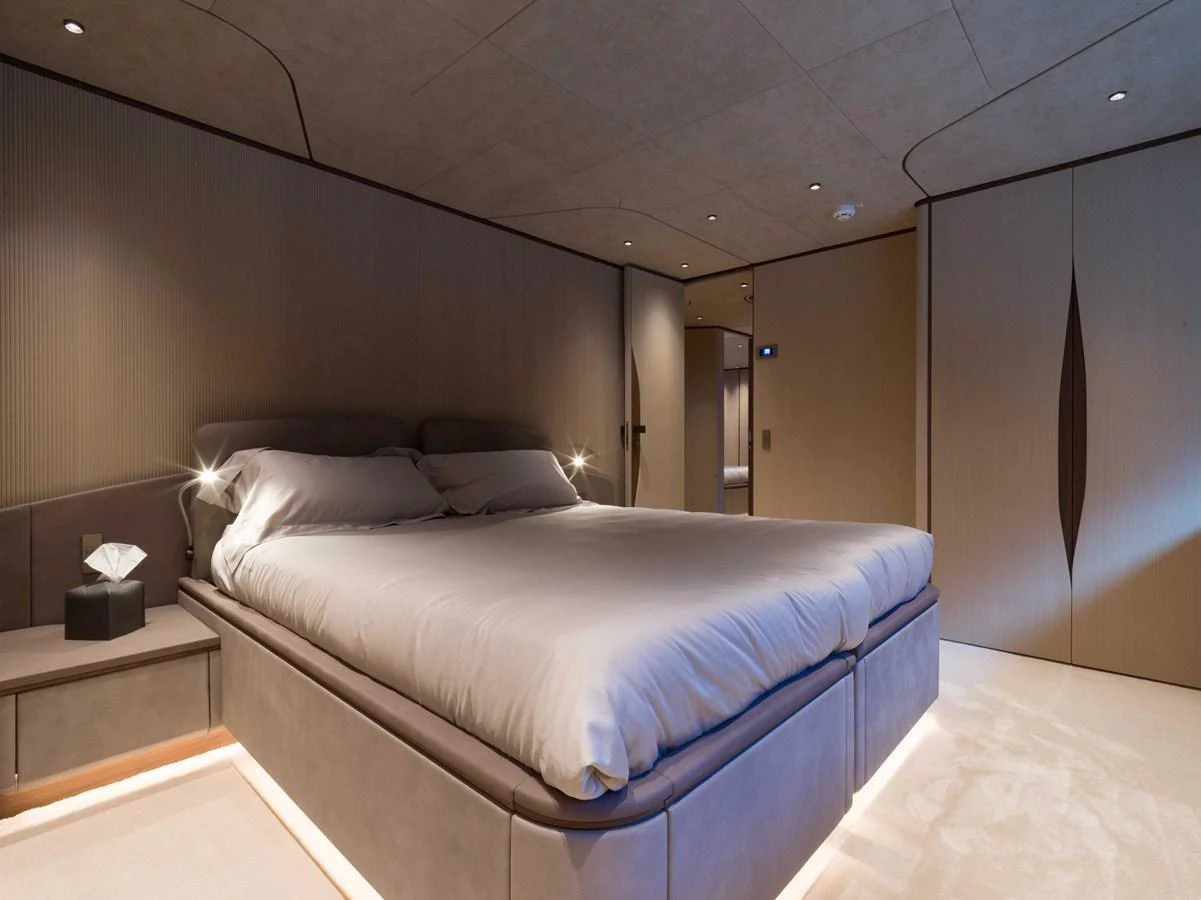 The stateroom features a luxurious bed with modern lighting and elegant design. aboard PESA II Yacht for Sale