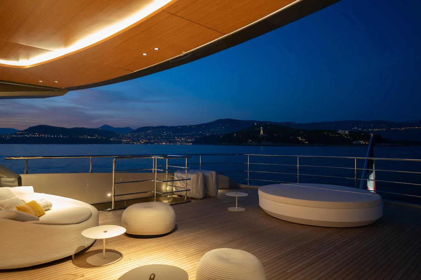 The aft deck offers a luxurious outdoor lounging area with stunning evening views over the water. aboard PESA II Yacht for Sale