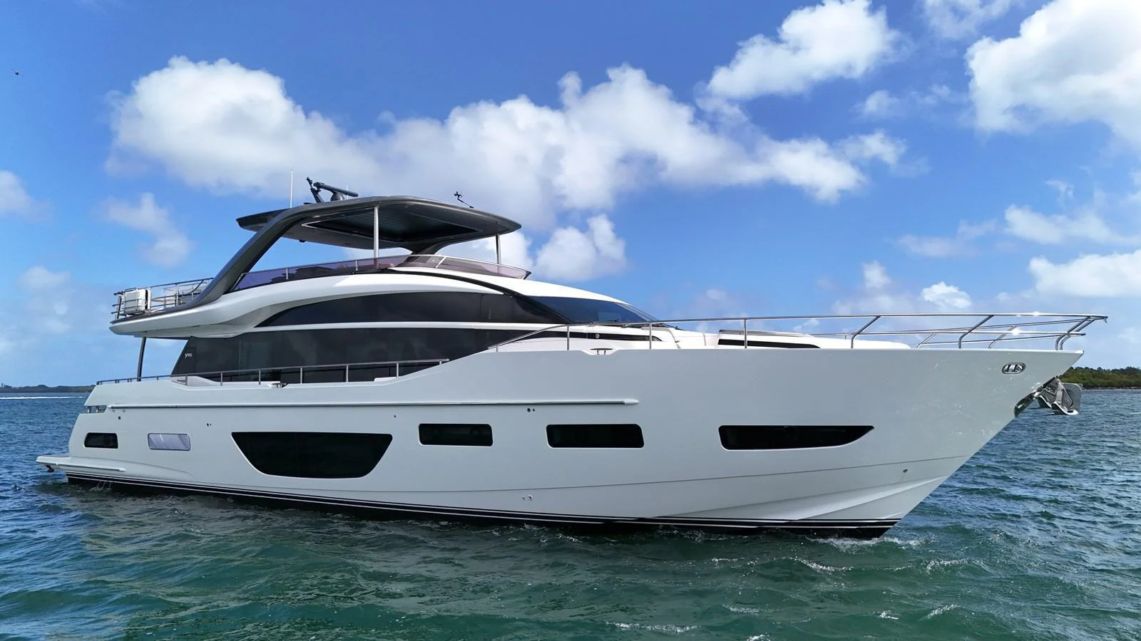 A sleek, modern yacht cruising on calm waters under a bright blue sky. aboard RECORD YEAR Yacht for Sale