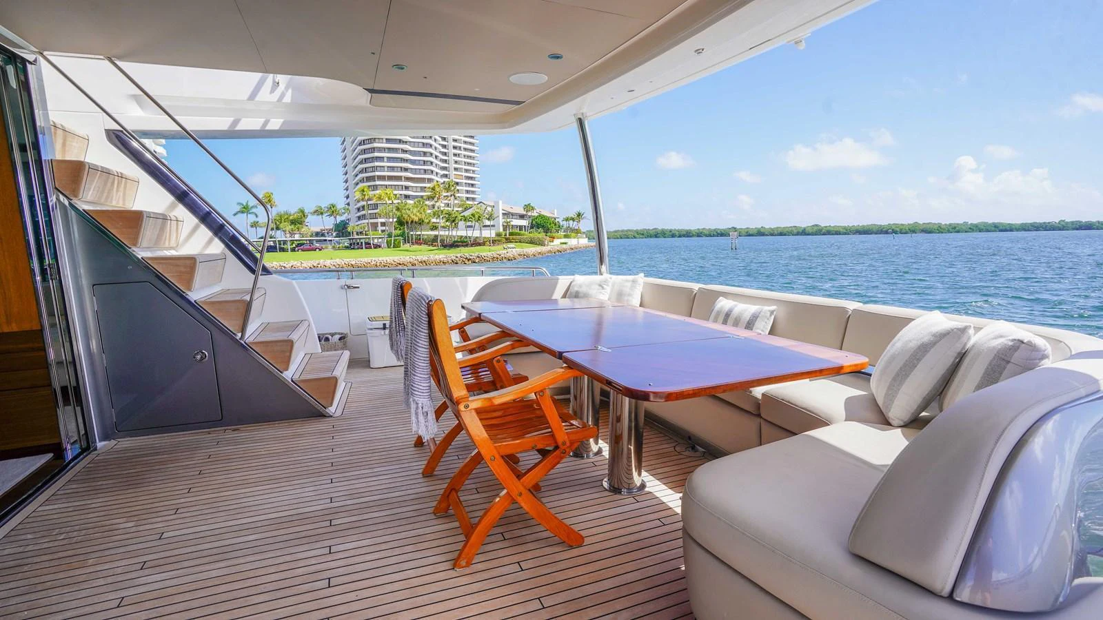 The aft deck features a spacious seating area with a dining table, perfect for al fresco meals with a stunning view. aboard RECORD YEAR Yacht for Sale