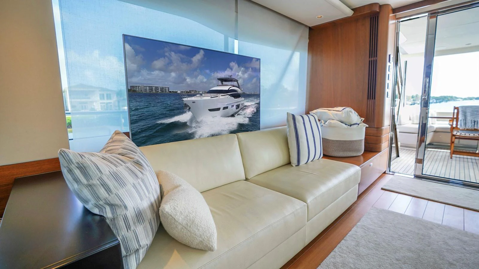 A luxurious interior seating area with a comfortable sofa and a large window providing a view of the sea. aboard RECORD YEAR Yacht for Sale