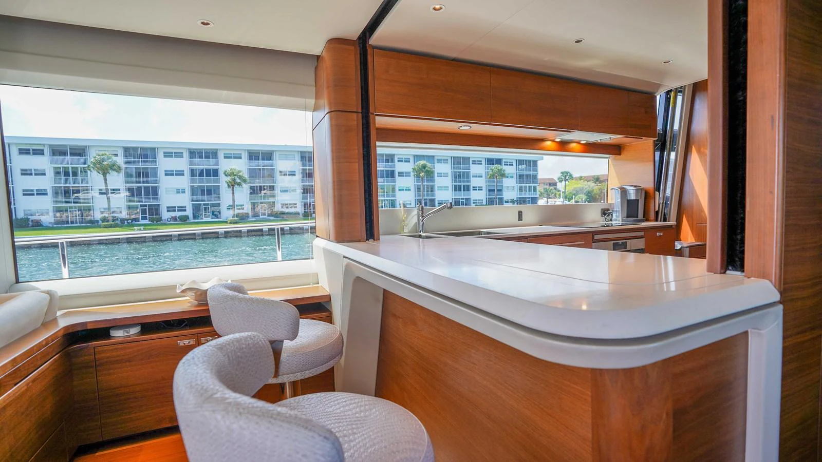 The yacht's galley features modern wooden cabinetry and a sleek countertop with comfortable seating. aboard RECORD YEAR Yacht for Sale