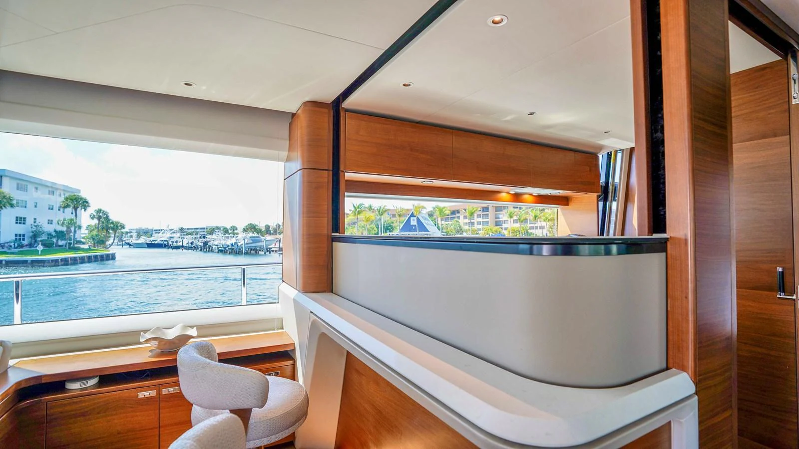 The yacht's interior features a stylish and modern design with ample natural light and a view of the marina. aboard RECORD YEAR Yacht for Sale