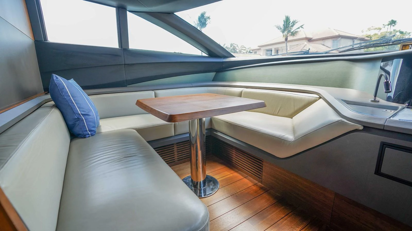 The saloon features a cozy seating area with a wooden table and large windows for natural light. aboard RECORD YEAR Yacht for Sale