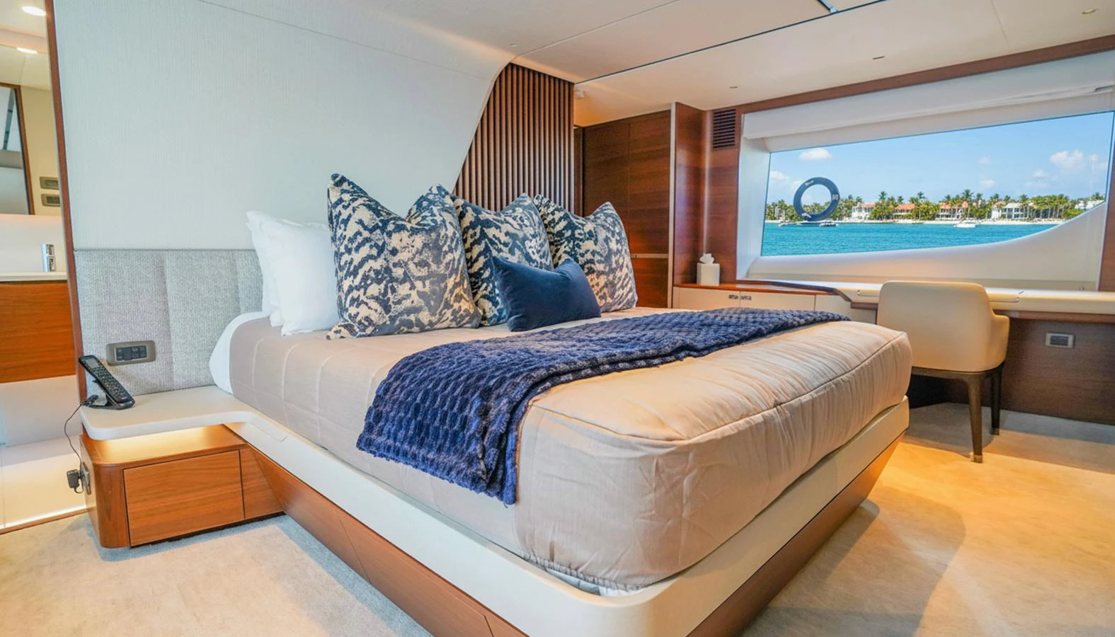 The master stateroom features a luxurious bed with elegant bedding and a stunning view through a large window. aboard RECORD YEAR Yacht for Sale