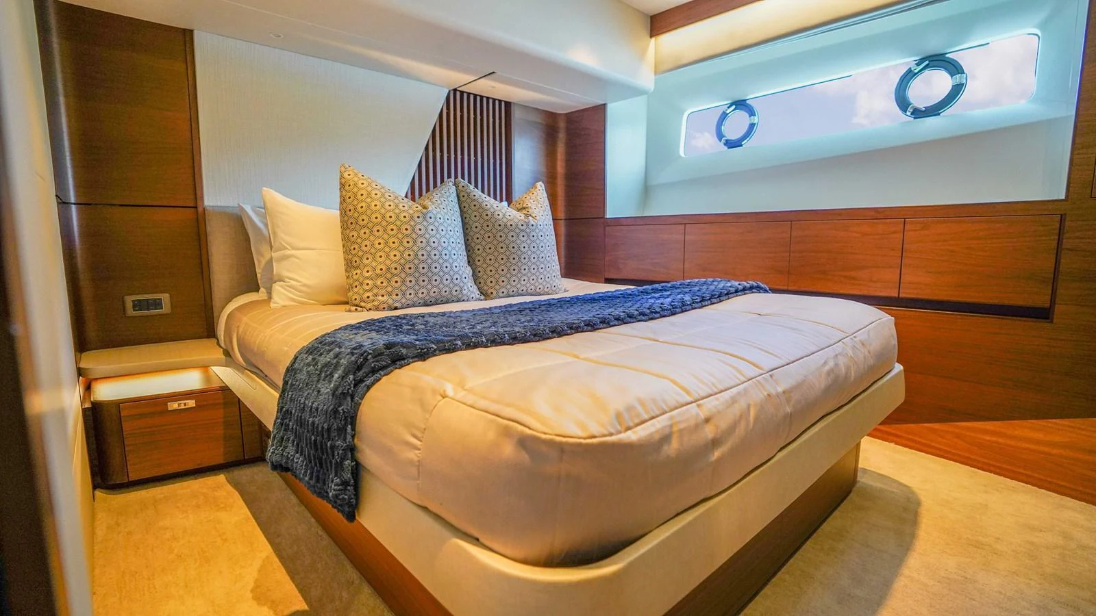 The stateroom features a plush bed with elegant bedding and ample natural light from the porthole windows. aboard RECORD YEAR Yacht for Sale