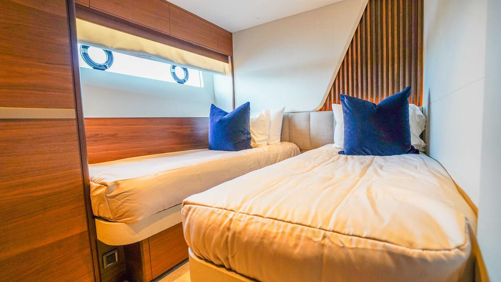 The twin stateroom features two comfortable single beds with plush pillows and modern wooden accents. aboard RECORD YEAR Yacht for Sale