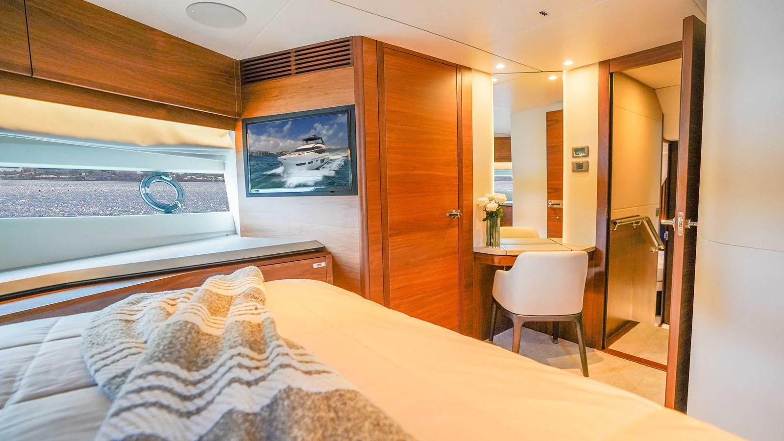 The stateroom features a cozy bed, wooden accents, and a small desk area, creating a warm and inviting atmosphere. aboard RECORD YEAR Yacht for Sale