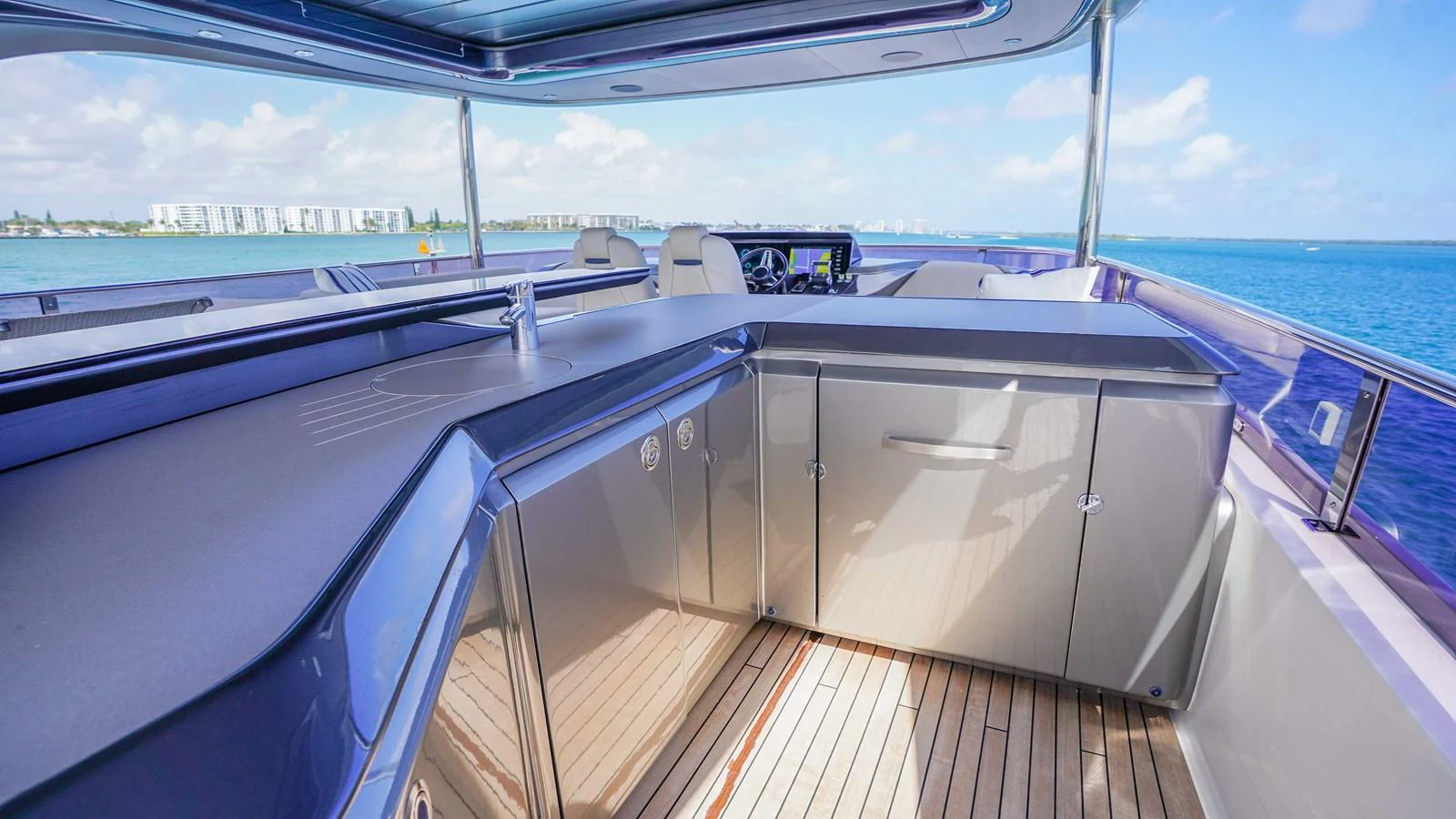 The flybridge features a sleek bar area with a stunning ocean view. aboard RECORD YEAR Yacht for Sale