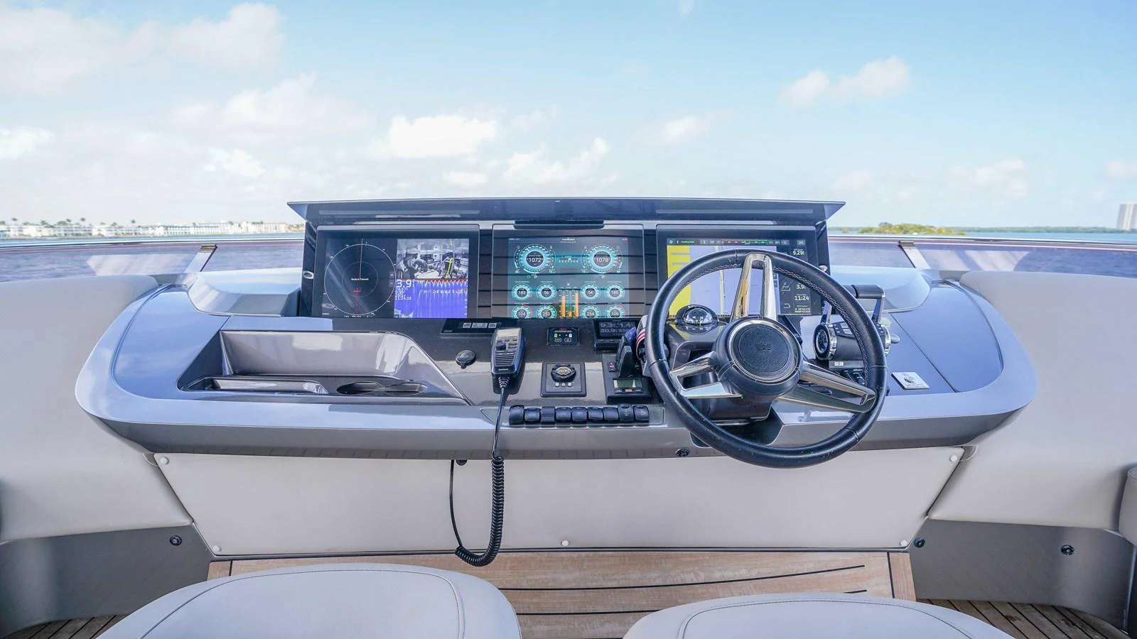 The helm station features advanced navigation equipment and a sleek steering wheel, offering a commanding view of the water. aboard RECORD YEAR Yacht for Sale