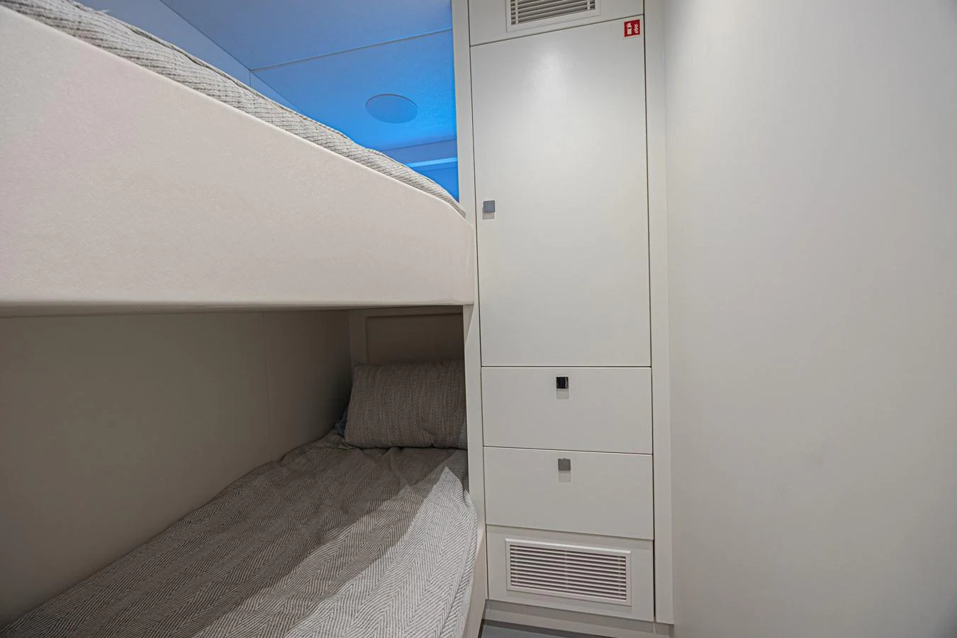 A cozy cabin with bunk beds and modern storage solutions. aboard HIDEOUT Yacht for Sale