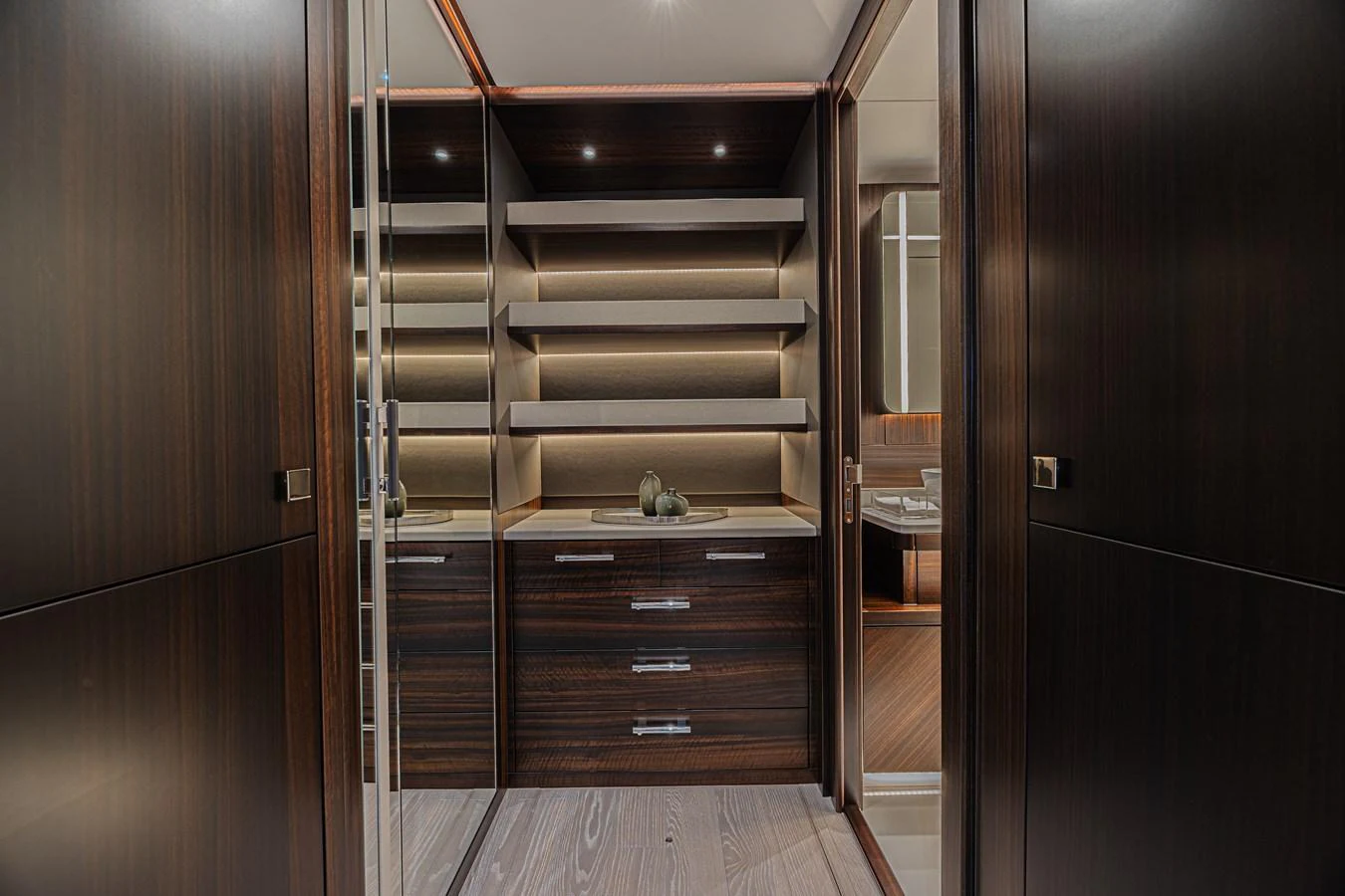 The image showcases a luxurious interior space with dark wood finishes and modern shelving. aboard HIDEOUT Yacht for Sale