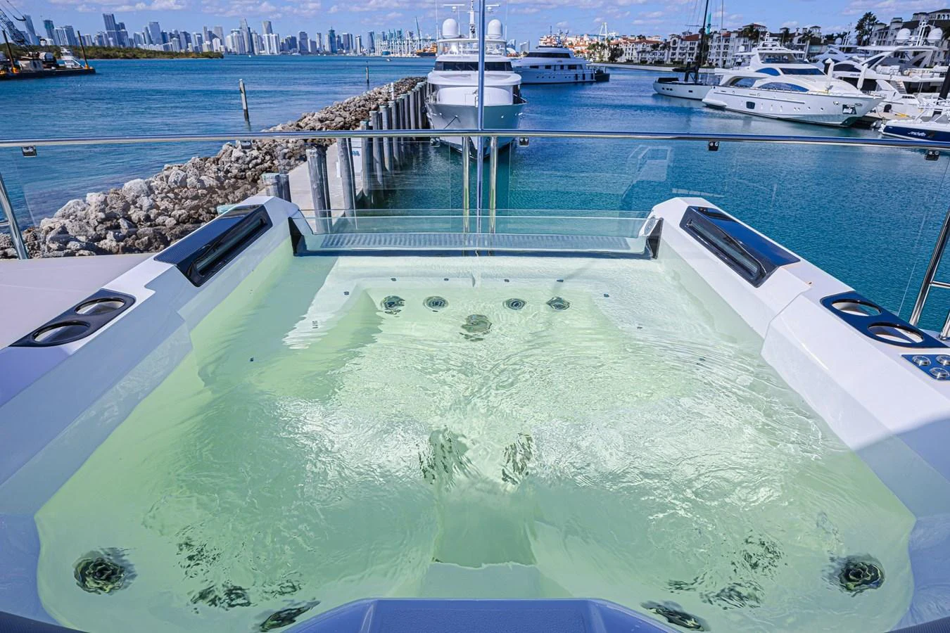 The yacht features a luxurious jacuzzi with stunning views of the marina and city skyline. aboard HIDEOUT Yacht for Sale