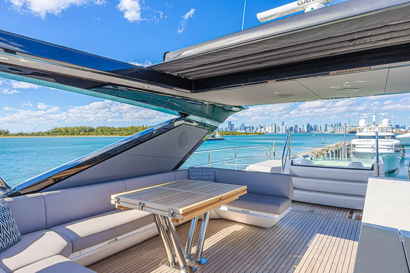 The flybridge offers a spacious seating area with a retractable roof and stunning views of the water and city skyline. aboard HIDEOUT Yacht for Sale