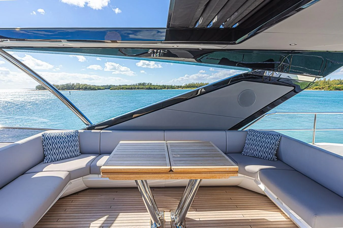 The flybridge offers a spacious seating area with a wooden table, perfect for enjoying the scenic views. aboard HIDEOUT Yacht for Sale