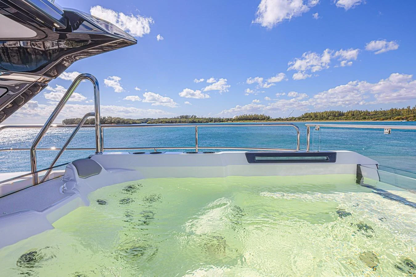 A luxurious jacuzzi on the deck offers a serene view of the water and distant shoreline. aboard HIDEOUT Yacht for Sale