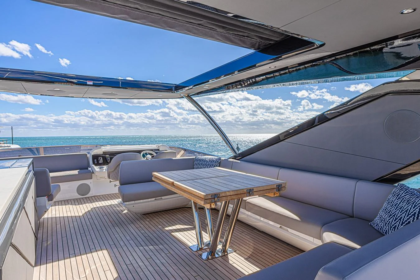 The flybridge offers a spacious seating area with a sleek table, perfect for enjoying the ocean views. aboard HIDEOUT Yacht for Sale