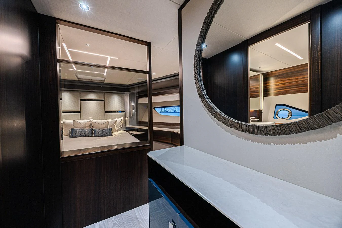 The image showcases a luxurious stateroom with a view into a cozy bedroom area. aboard HIDEOUT Yacht for Sale
