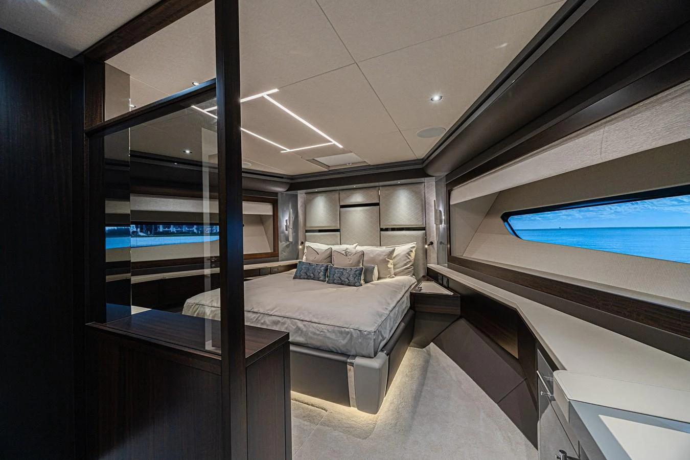 The master stateroom features a luxurious bed with panoramic windows offering stunning ocean views. aboard HIDEOUT Yacht for Sale