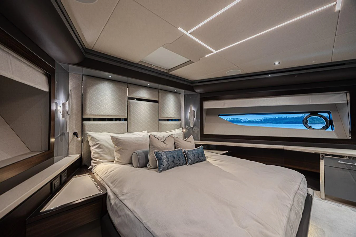 The luxurious stateroom features a plush bed, elegant lighting, and a scenic window view. aboard HIDEOUT Yacht for Sale