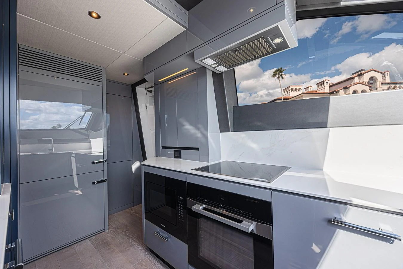 The yacht's galley features modern appliances and sleek cabinetry with a view of the outside. aboard HIDEOUT Yacht for Sale