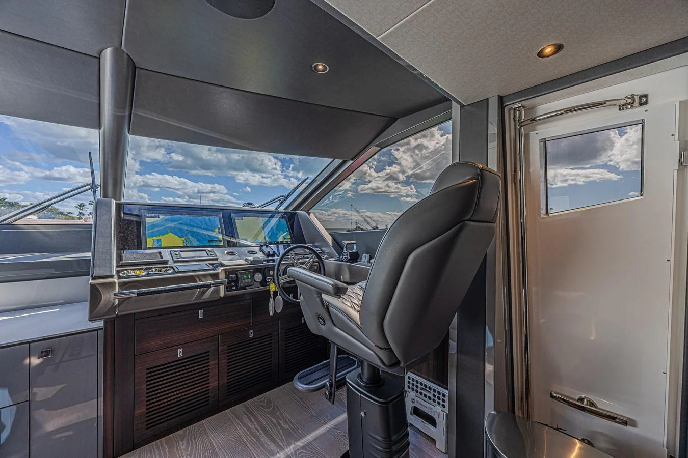 The helm station offers a commanding view with state-of-the-art navigation equipment and a comfortable captain's chair. aboard HIDEOUT Yacht for Sale