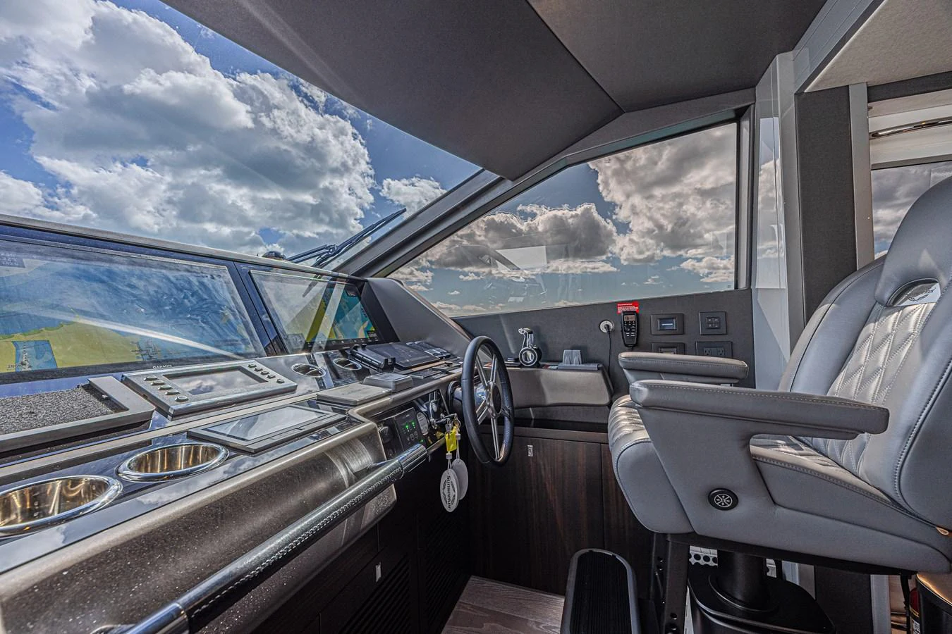 The helm station features state-of-the-art navigation equipment and a luxurious captain's chair, offering panoramic views through large windows. aboard HIDEOUT Yacht for Sale