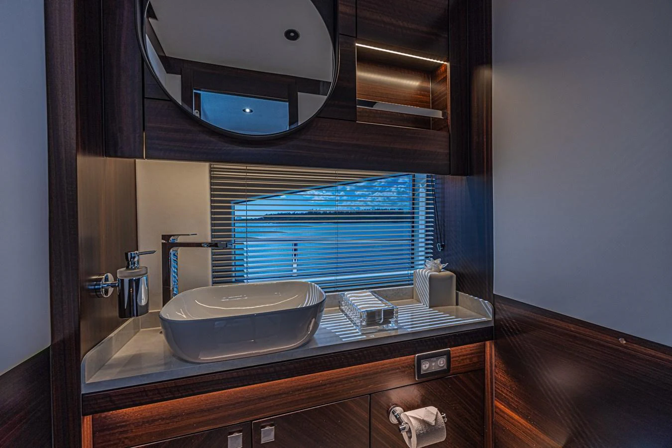 The yacht's bathroom features a sleek, modern design with a large mirror and a stylish sink. aboard HIDEOUT Yacht for Sale
