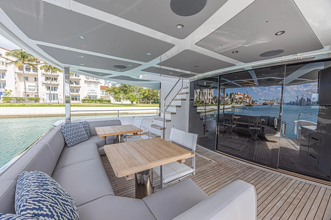 The aft deck features a spacious seating area with modern furnishings and a beautiful view of the water. aboard HIDEOUT Yacht for Sale