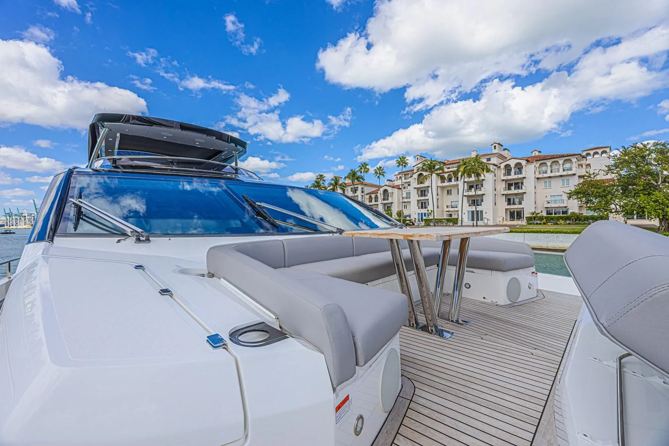 The flybridge offers a spacious seating area with a sleek table, perfect for enjoying scenic views. aboard HIDEOUT Yacht for Sale