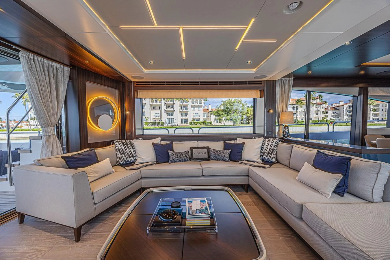 The salon features a spacious and elegant seating area with modern lighting and large windows offering scenic views. aboard HIDEOUT Yacht for Sale
