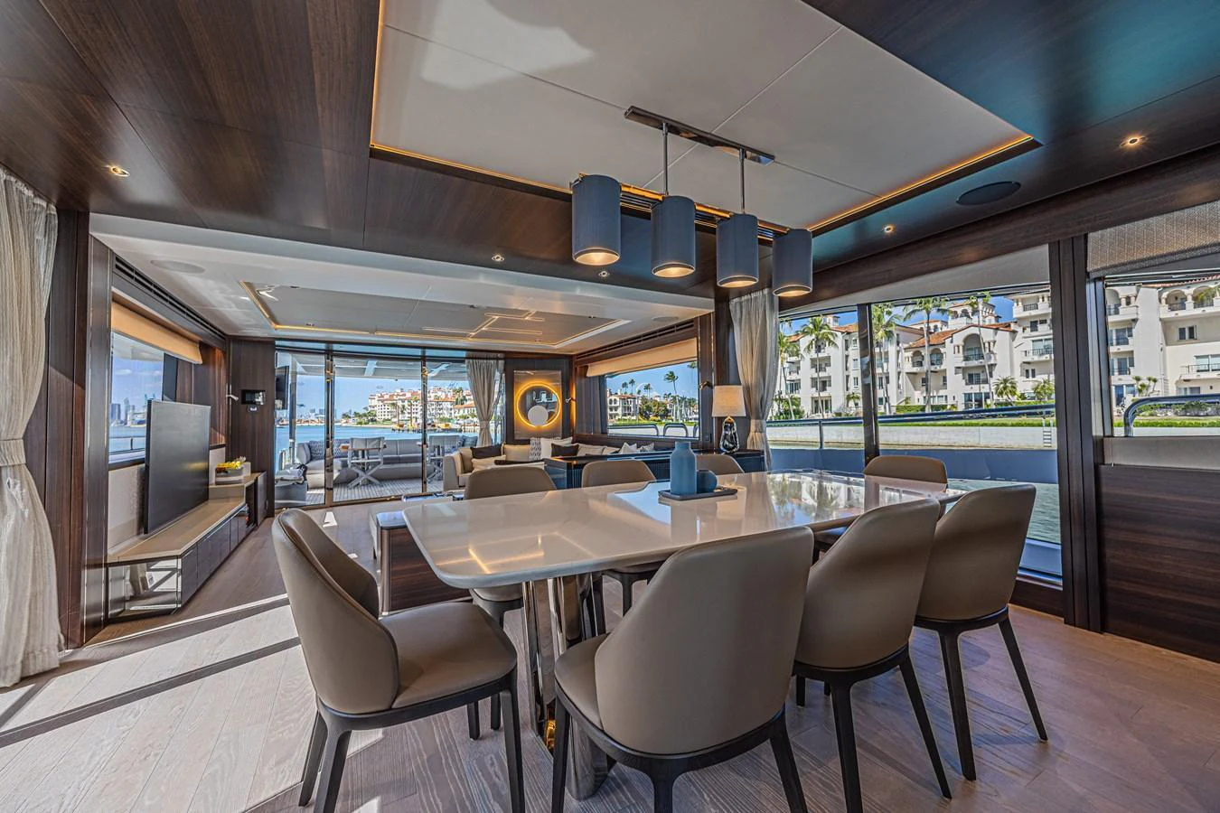 The yacht's dining area features a modern table with comfortable seating and expansive windows offering stunning waterfront views. aboard HIDEOUT Yacht for Sale