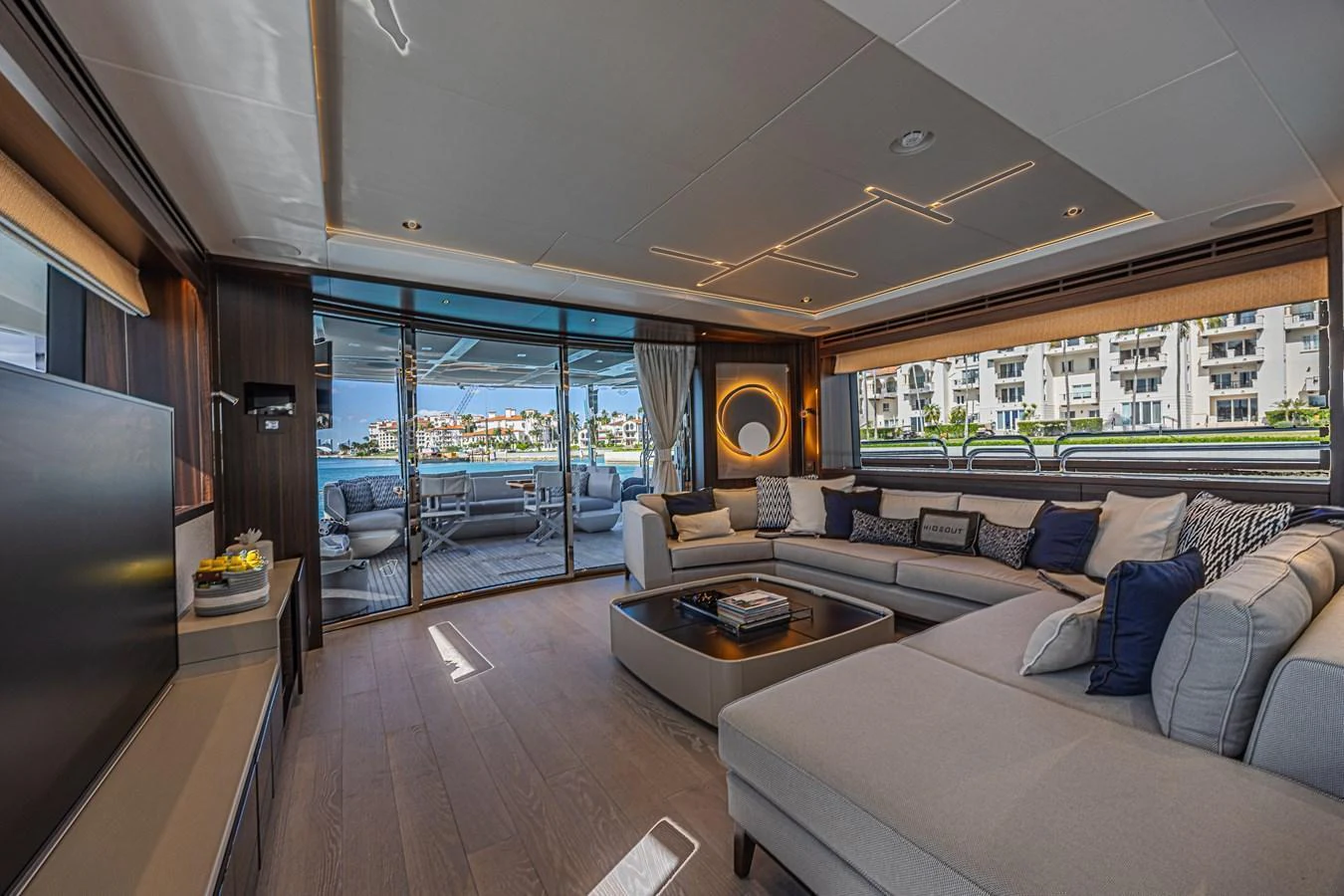 The salon offers a spacious and luxurious seating area with a view of the water through large windows. aboard HIDEOUT Yacht for Sale
