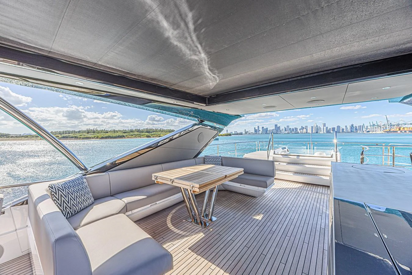 The aft deck offers a spacious and shaded area with comfortable seating and a dining table, perfect for enjoying the scenic views. aboard HIDEOUT Yacht for Sale