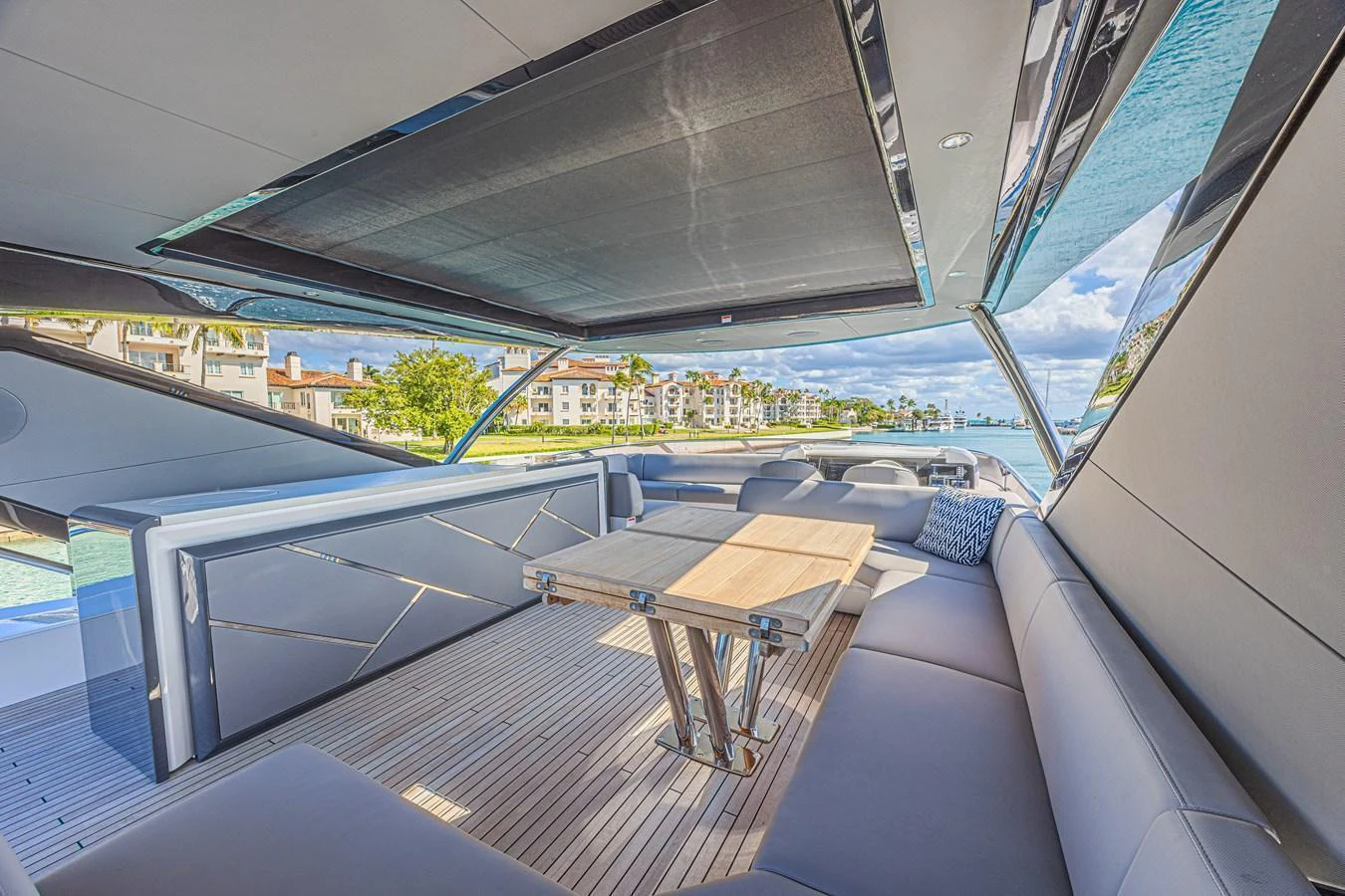 The aft deck features a spacious seating area with a wooden table, perfect for outdoor relaxation and dining. aboard HIDEOUT Yacht for Sale